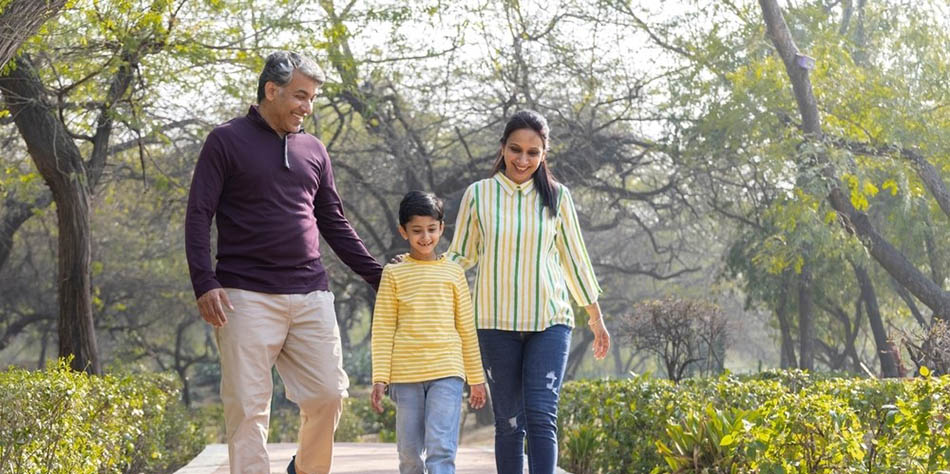 A family walks outside in a park.