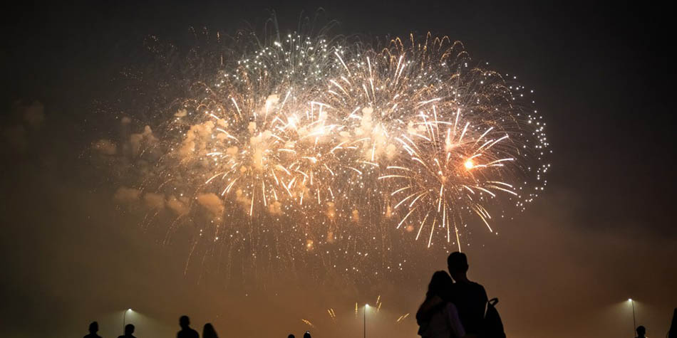 People watching fireworks at night.